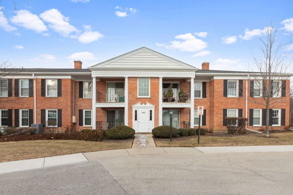 Front view of a two-story brick building with white columns and shutters.