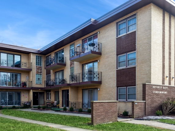 Front view of a multi-story condominium building with balconies.
