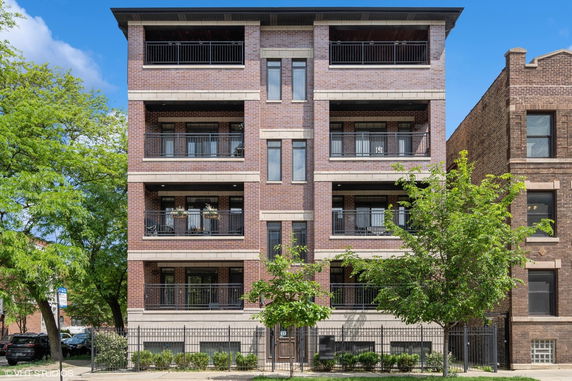 Front view of a multi-story residential building with balconies.
