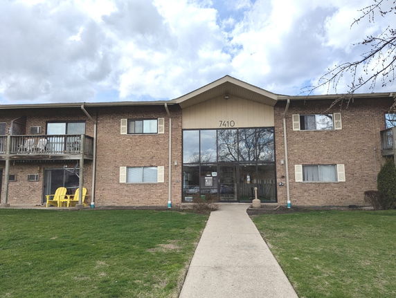 Front view of a two-story brick apartment building with balconies.