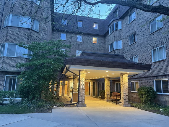 Front view of a multi-story brick building with an entrance canopy.