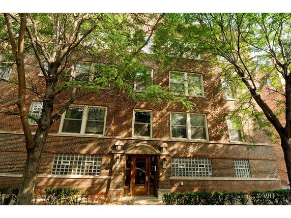 Front view of a multi-story brick building with large windows and a central entrance.