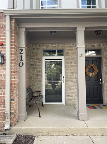 Front view of a house entrance with a brick and stone facade.