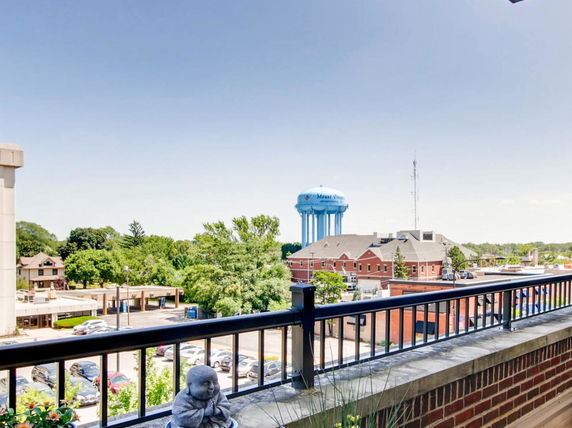 Panoramic view from a balcony showing a water tower and nearby buildings.