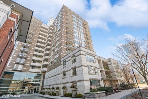 Front view of a multi-story apartment building with balconies and modern architecture.