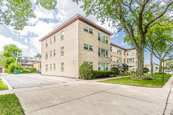 Front view of a three-story apartment building with multiple windows.
