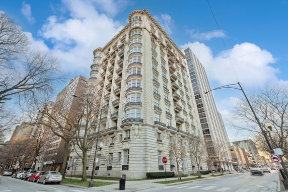 Front view of a multi-story historical building with ornate balconies and detailed architectural features.