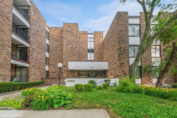 Front view of a multi-story brick building with balconies.