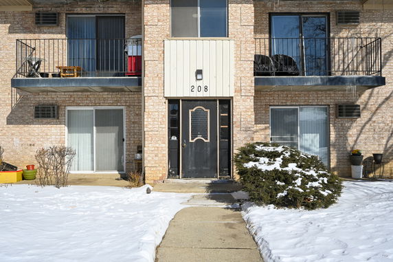 Front view of a brick apartment building with balconies.