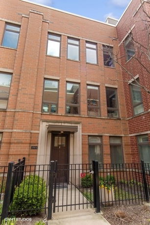 Front view of a multi-story brick townhouse.