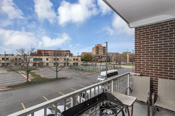 View from a balcony showing parking area and surrounding buildings.