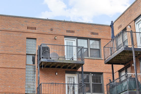 Front view of a brick apartment building with balconies.