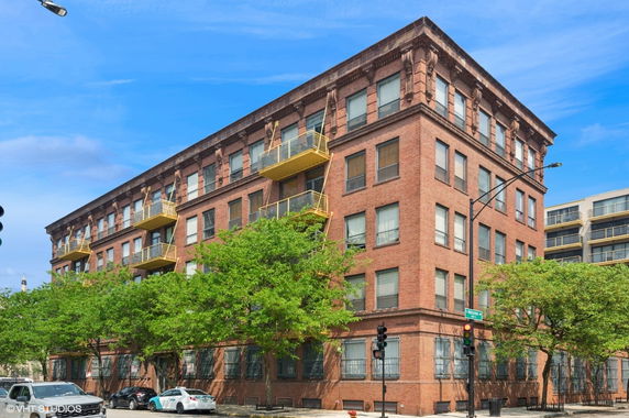 Front view of a multi-story brick building with yellow balconies.