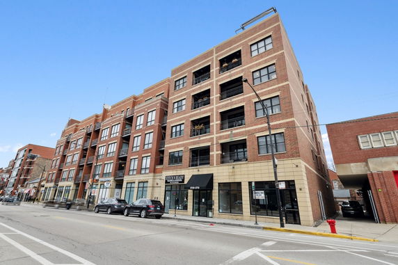 Front view of a multi-story brick building on a city street.