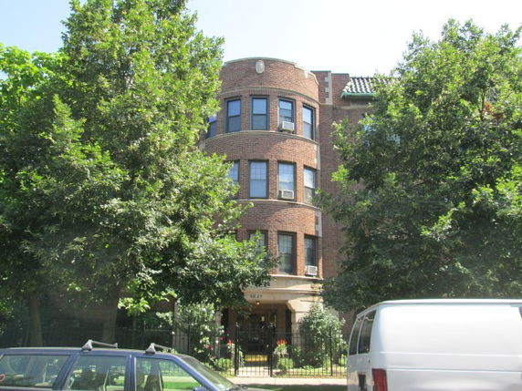 Front view of a multi-story brick building with rounded architectural features.