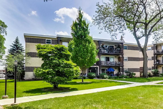 Front view of a three-story apartment building with balconies.