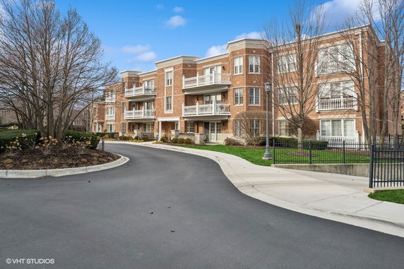 Front view of a multi-story brick apartment building with balconies.