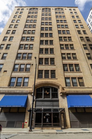 Front view of a multi-story condominium building with large windows.