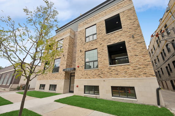 Front view of a multistory brick building with a central entrance.