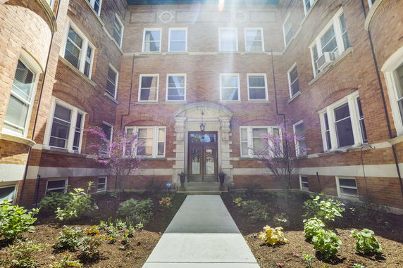 Front view of a multi-story brick building with ornamental entrance.