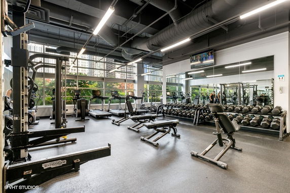 Interior view of a gym with exercise equipment and weights.