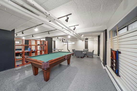 Recreation room with a billiards table and seating area.