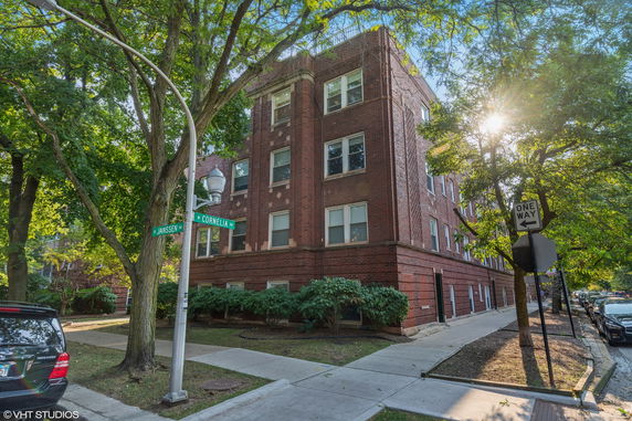 Front view of a multi-story brick building on a corner lot.