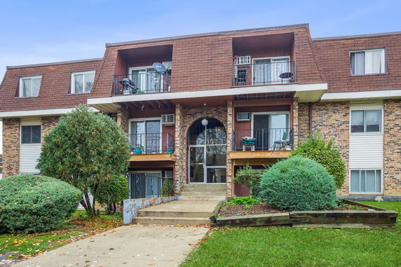 Front view of a multi-story residential building with balconies.