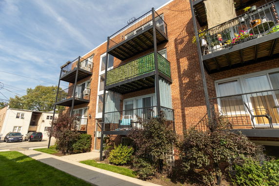 Front view of a multi-story apartment building with balconies.