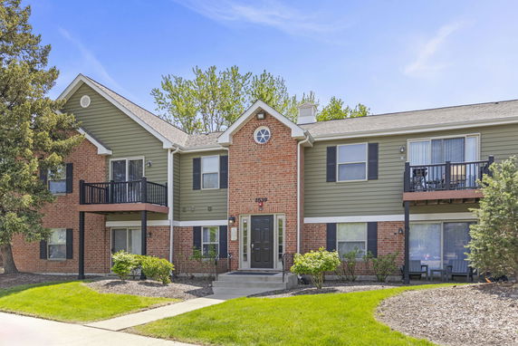 Front view of a two-story residential building with brick and siding exterior.