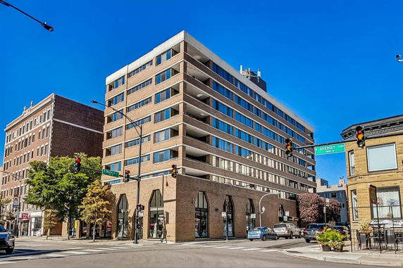 Front view of a multi-story building with large windows and a modern design.