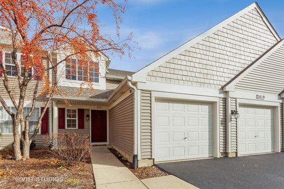 Front view of a two-story house with a single garage and red front door.