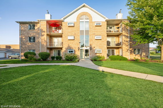 Front view of a three-story apartment building with balconies.
