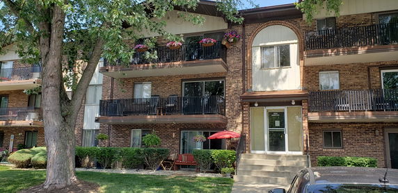 Front view of a multi-story brick building with balconies.