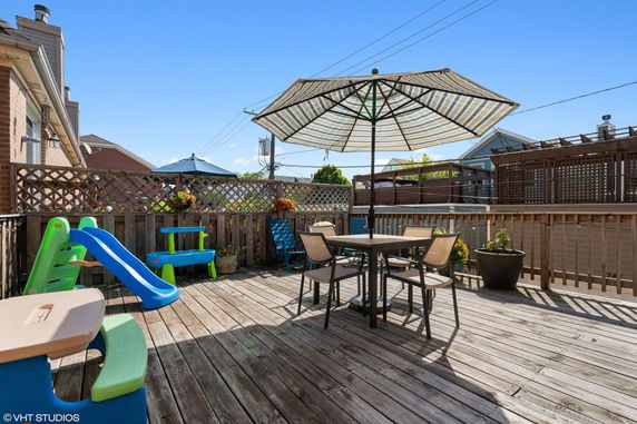 Rooftop deck with seating area and children's play equipment.