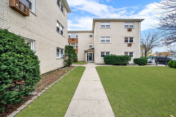 Front view of a multi-story brick apartment building.