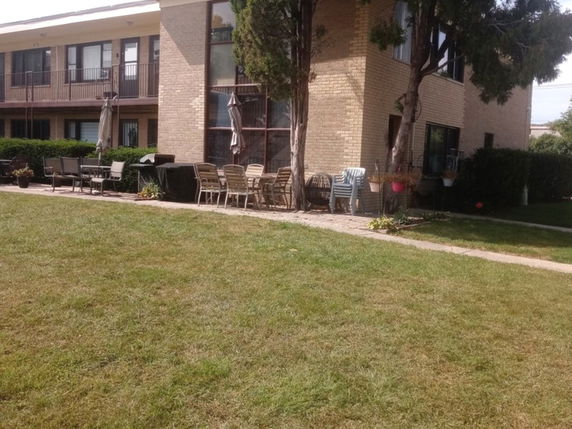 Front view of a two-story building with a patio area.