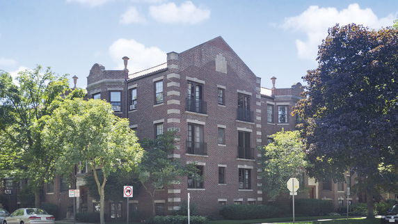 Front view of a multi-story brick building with decorative architectural details.