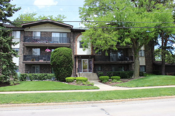 Front view of a multi-story residential building with balconies.
