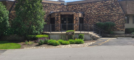 Front view of a building with a brick exterior and a small entrance porch.