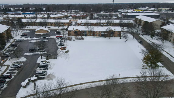 Panoramic view of a residential area with snow-covered grounds and parking lots.