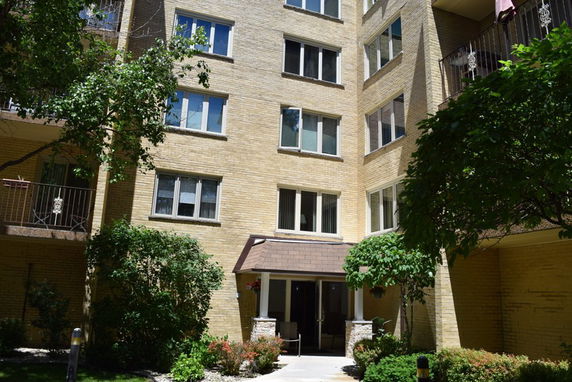 Front view of a multi-story apartment building with a central entrance.