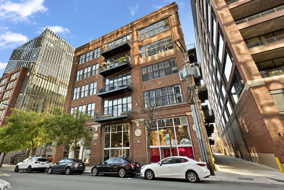 Front view of a multi-story brick building with large windows and balconies.