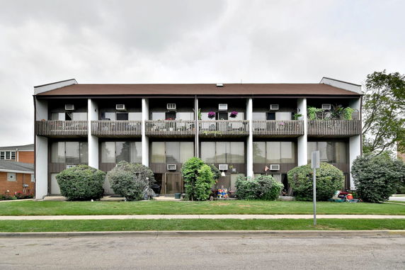 Front view of a three-story residential building with balconies.