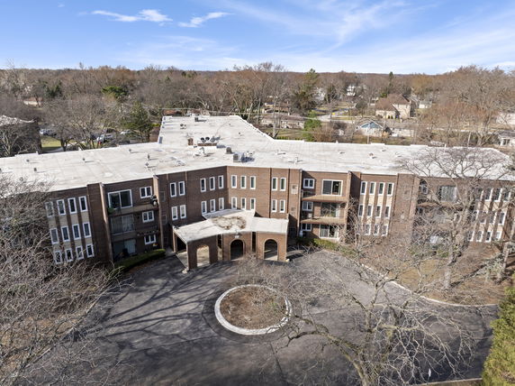 Front view of a multi-story brick building with a circular driveway.