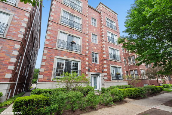 Front view of a multi-story brick building with balconies.