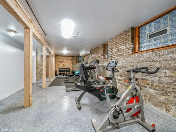 Room with exercise equipment including a stationary bike and treadmill.