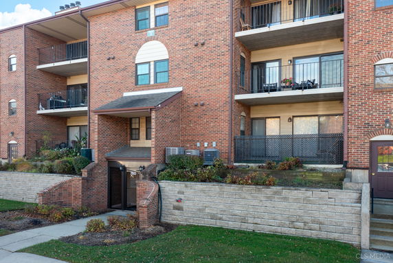 Front view of a multi-story brick building with balconies.