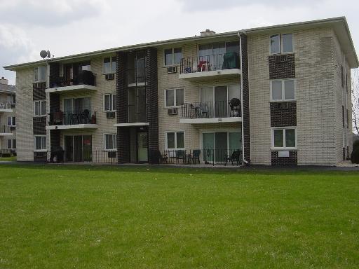 Front view of a multi-story apartment building with balconies.