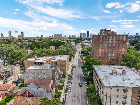 Panoramic view of a cityscape with buildings and trees lining a street.